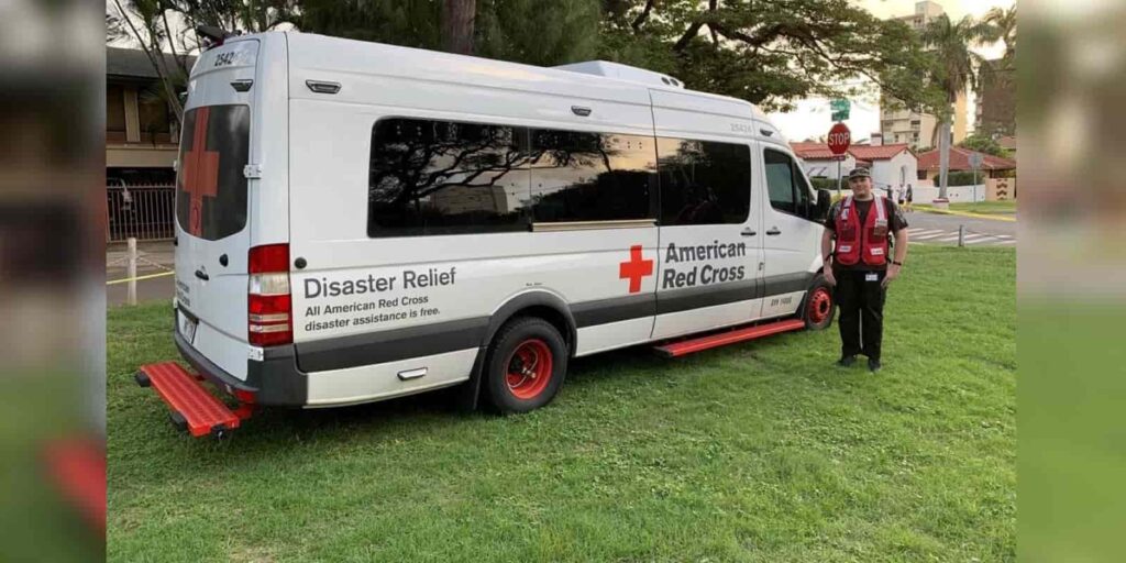 Timothy Duston standing in front of the Red Cross van