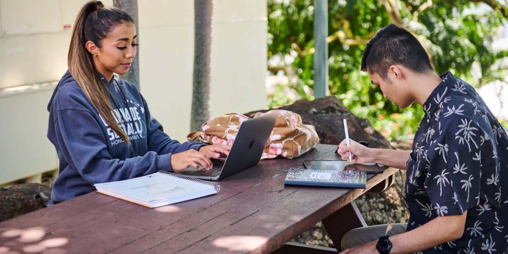 students studying together on a bench near Brogan Hall