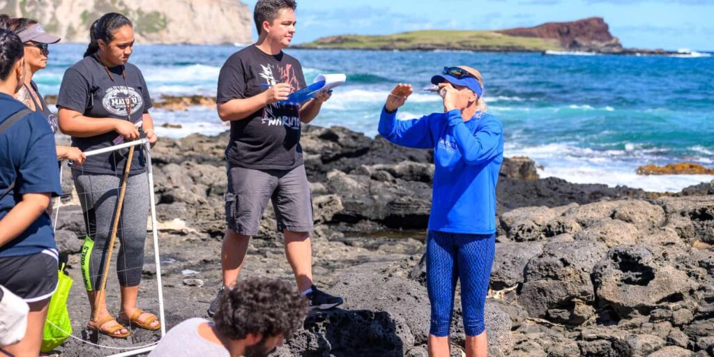 Dr. Gail Grabowsky, Dean of the School of Natural Sciences and Mathematics, with students at Makapuu Beach looking at tidepools