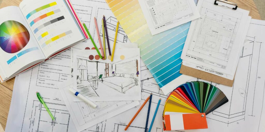 Blue prints, color swatch, pencil colors, sketches, plans and documents for a home renovation