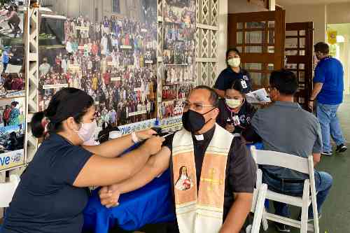 Chaminade nursing student taking a parishioner's blood pressure for the Parish Health Program