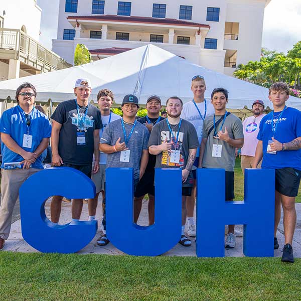 students standing in front of C U H letters