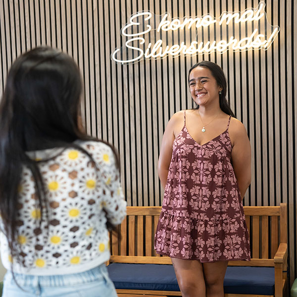 Chaminade females taking photos in front of the neon sign