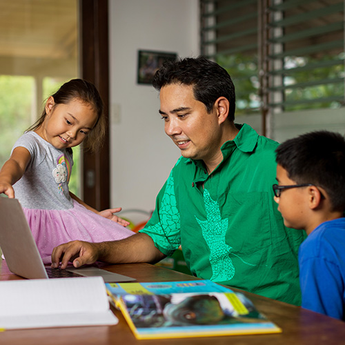 father with his kids while doing his homework